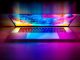 Laptop with abstract colorful wallpaper open on a wooden surface