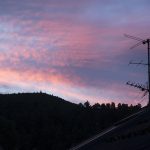 Antenne TV silhouettée contre un ciel crépusculaire rose et violet