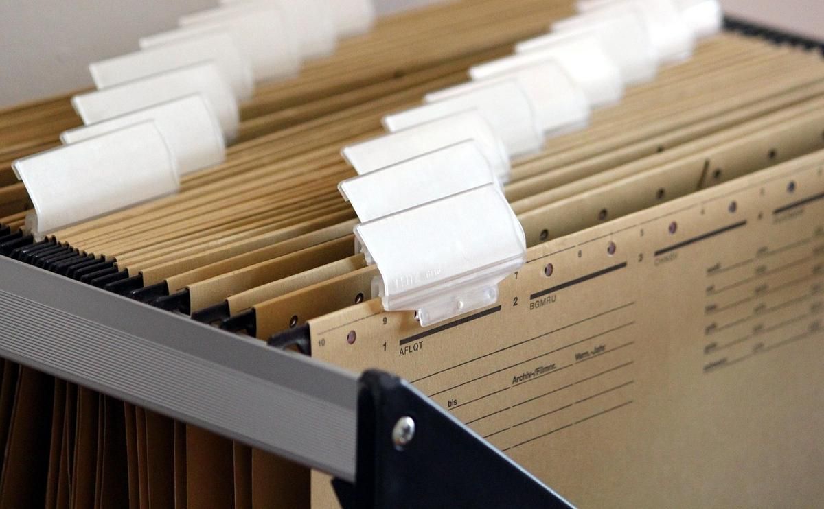 Étagère en bois avec dossiers et classeurs en carton, étiquettes blanches