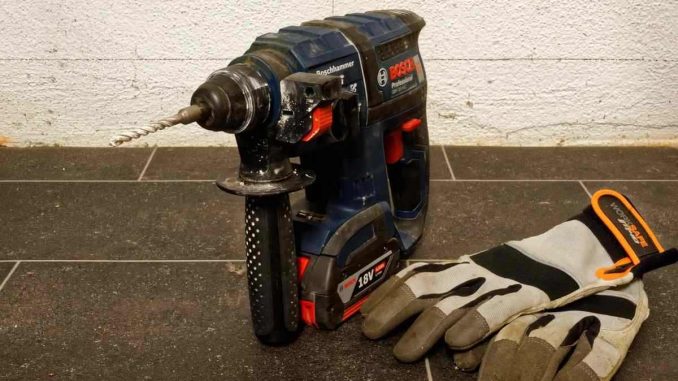 Perceuse et gants de travail sur un sol en carrelage