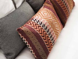 Coussins aux motifs géométriques et à carreaux disposés sur un canapé blanc
